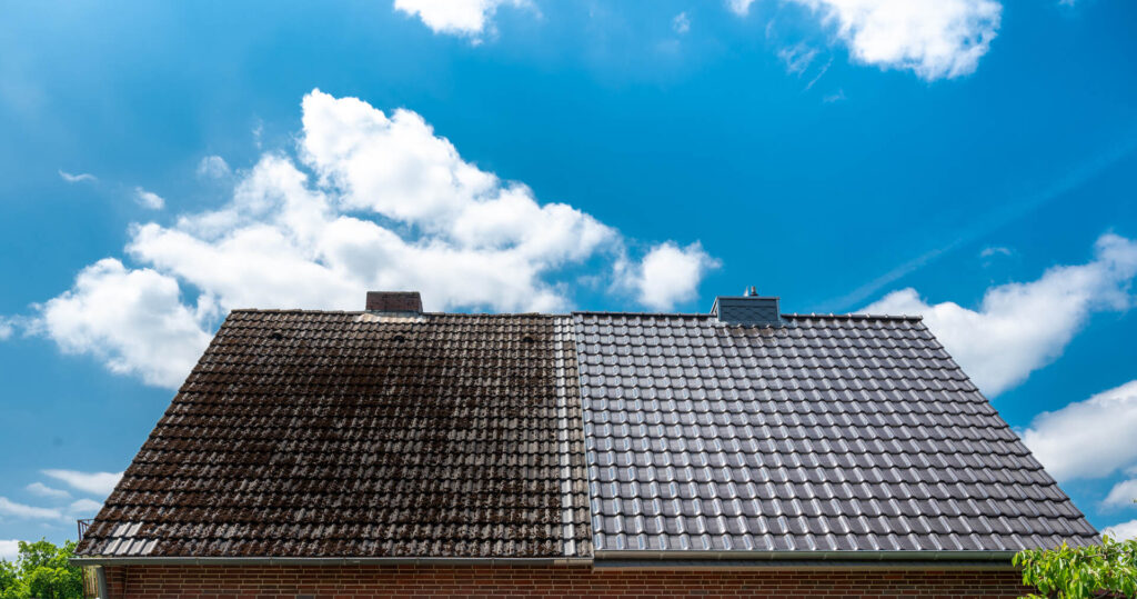 A half cleaned house roof shows the before and after effect of a roof cleaning