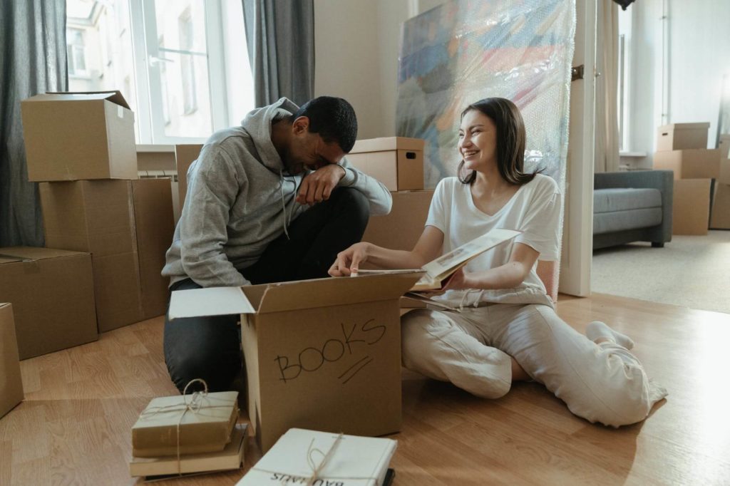 A man and a woman unpacking boxes after moving state to state 