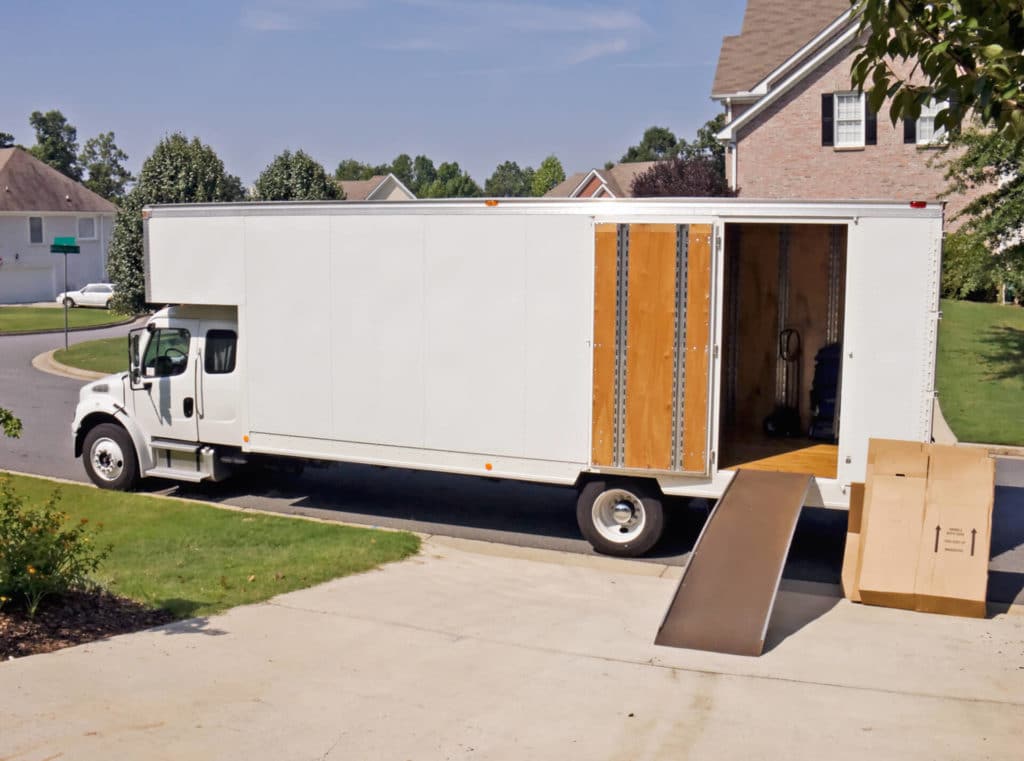 Cross-country moving truck parked in front of a house