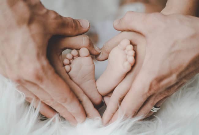 parents holding baby's feet