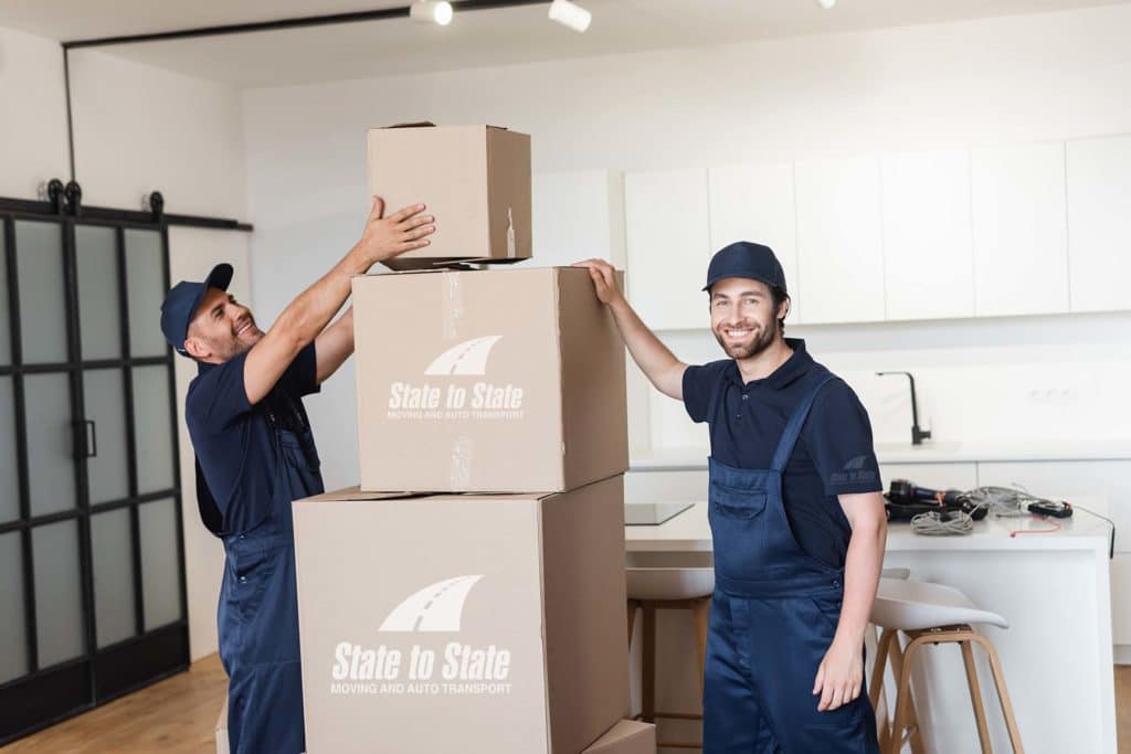 Movers stacking boxes with a brand logo on