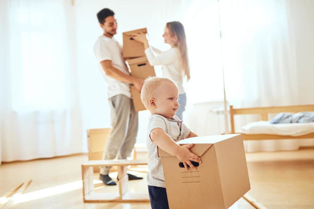 parents and toddler holding boxes