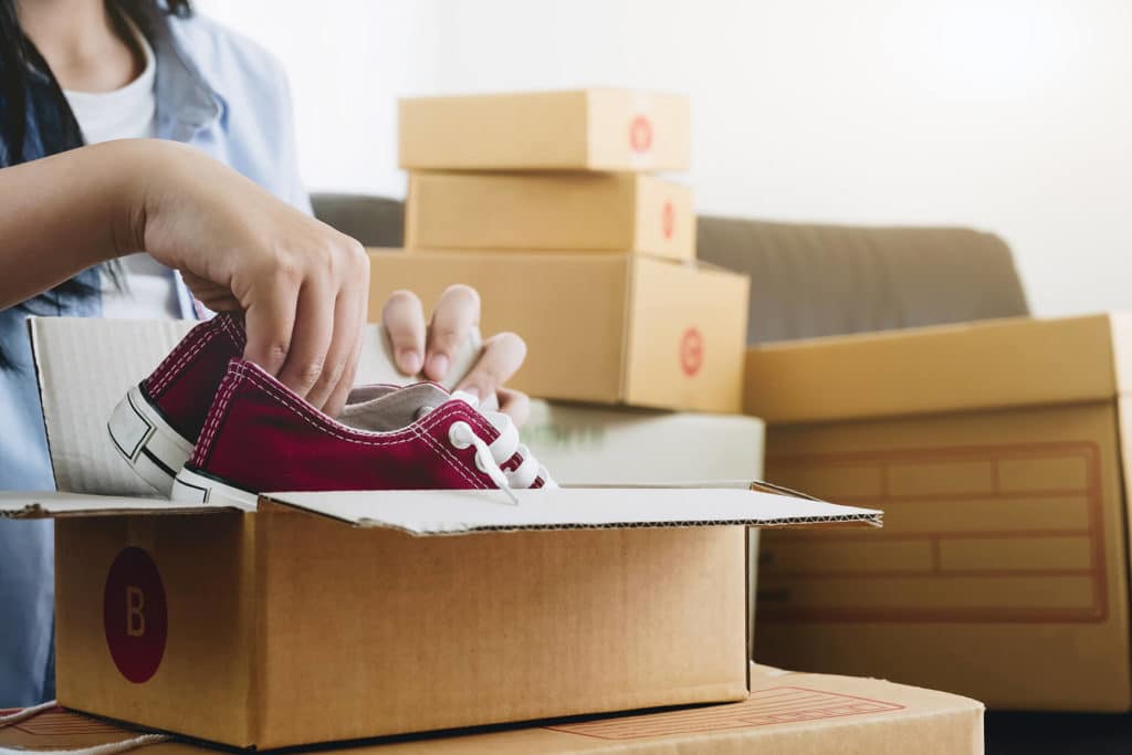 a person packaging sneakers for long-distance moving