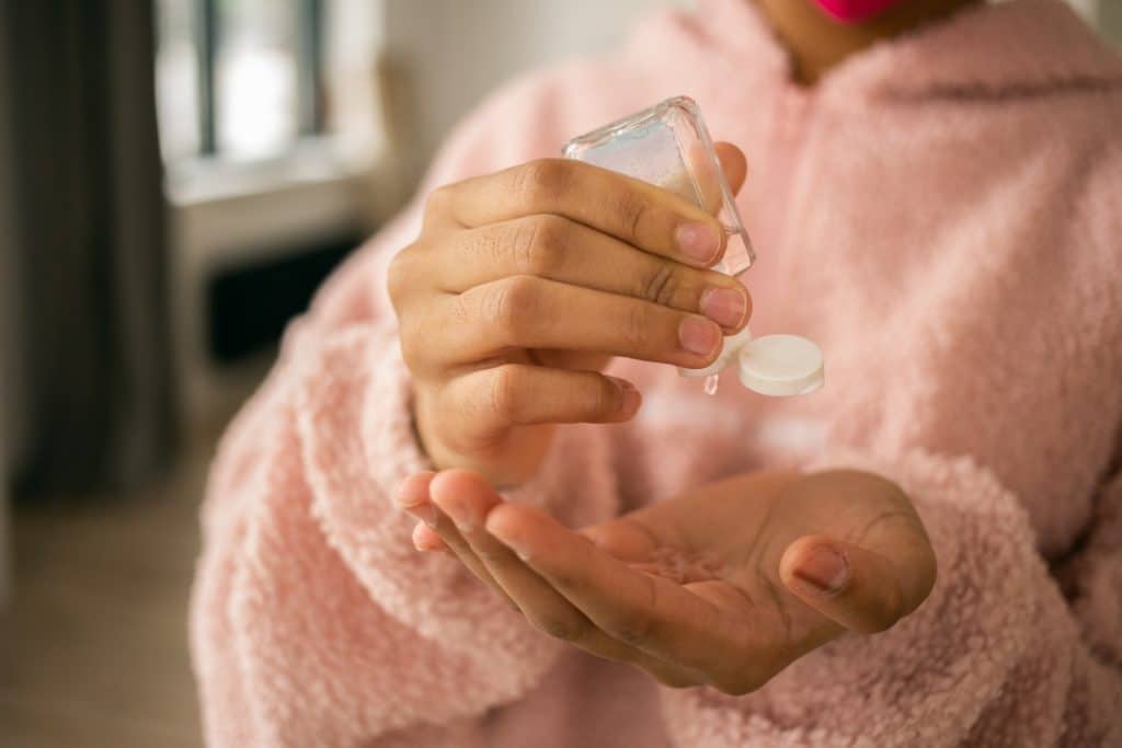  a girl in pink off-screen using hand sanitizer