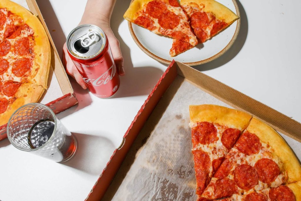 Half-eaten pizzas and cans of coke