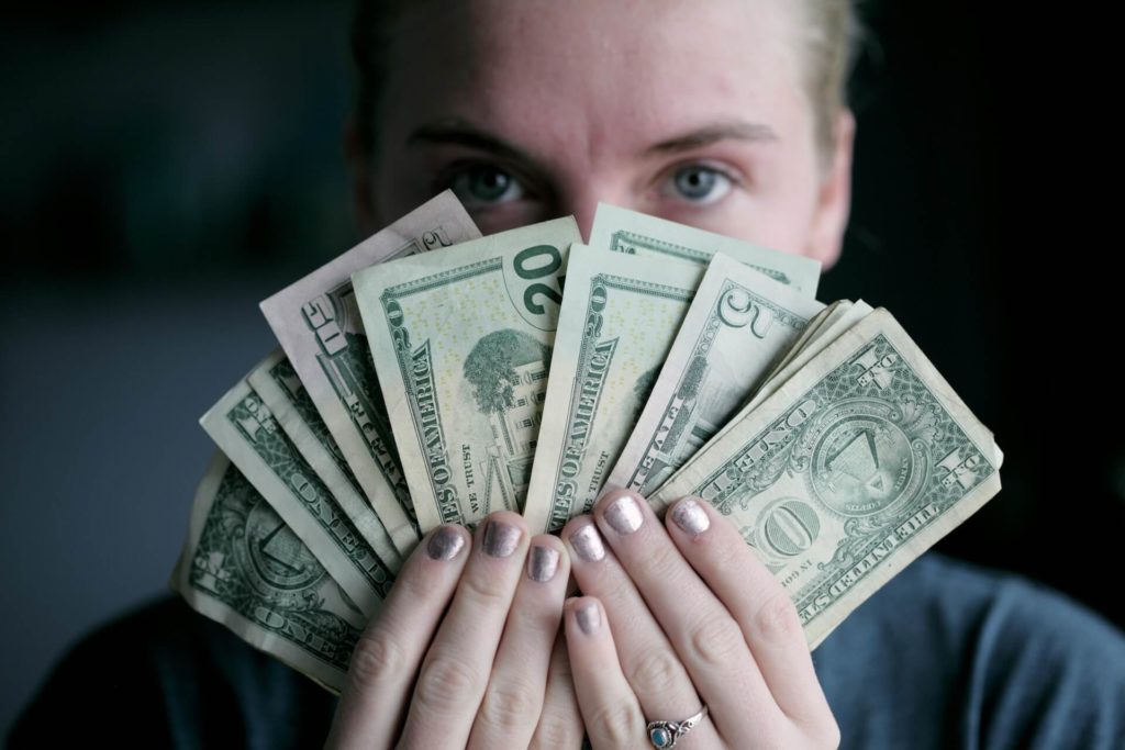A girl holding a bunch of dollar bills
