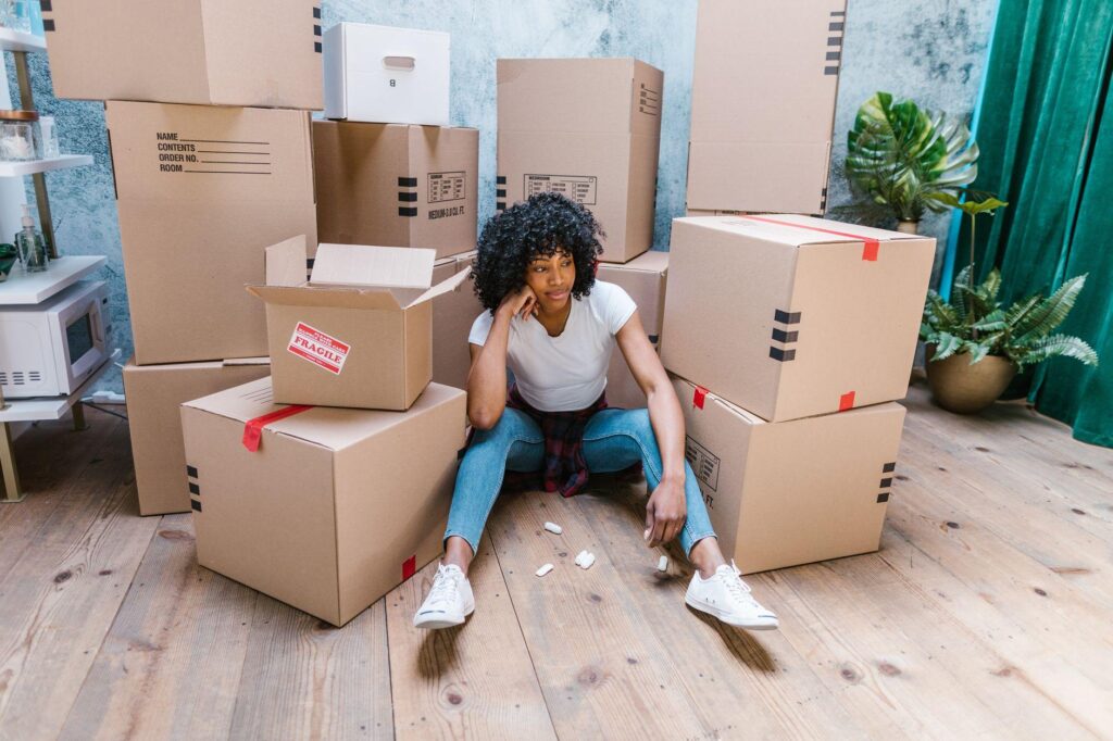 Girl surrounded by boxes while waiting for state-to-state movers