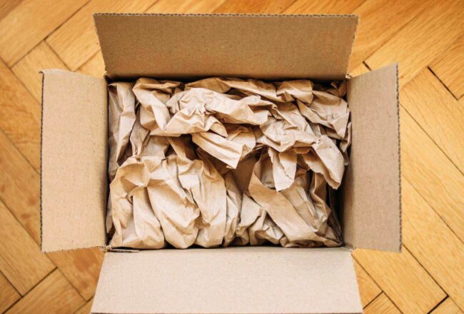 Box full of crumbled packing paper waiting to be used for moving state to state