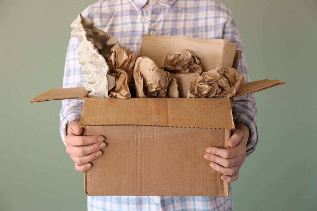 Man holding a box full of packing paper 