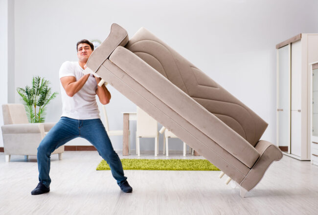 A man moving a couch