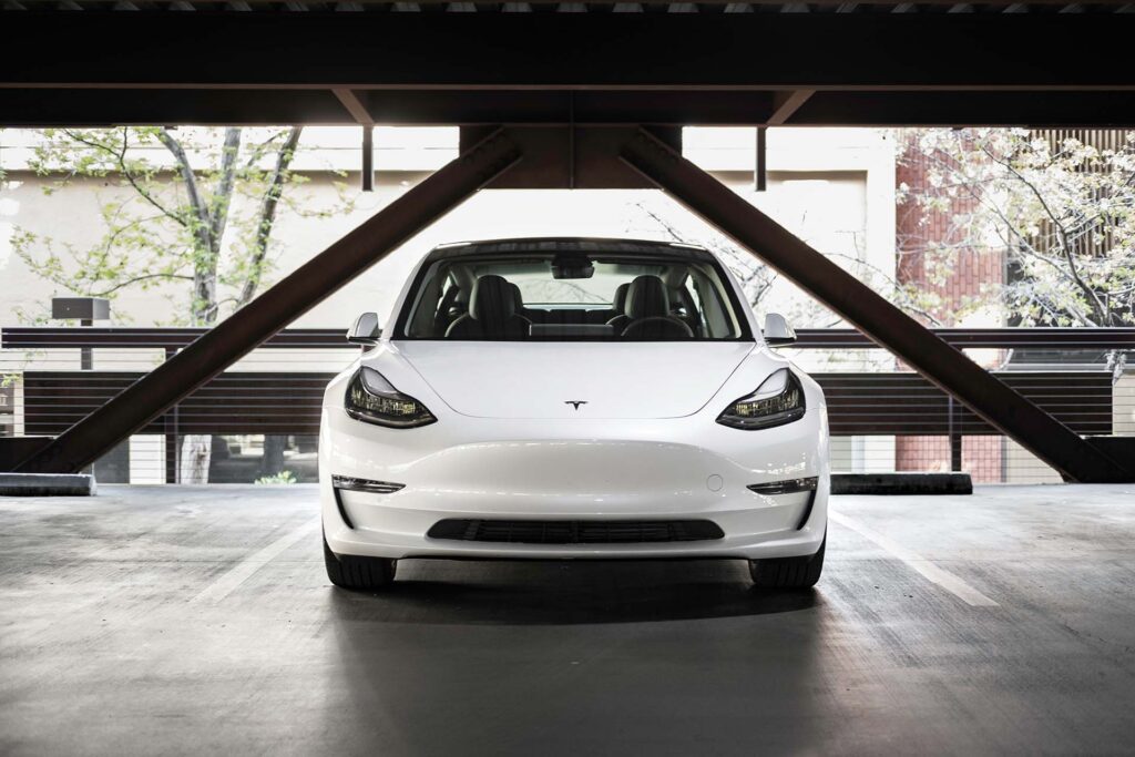A white Tesla parked in a garage