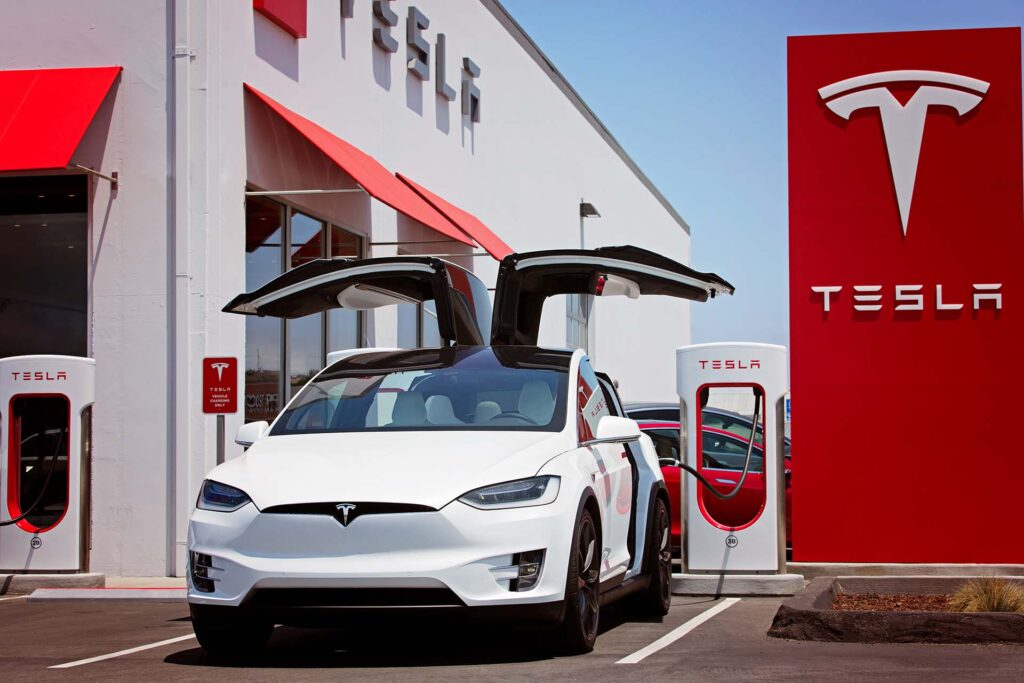 Seaside, CA - May 29, 2016: white tesla model x with falcon wing doors open charging at supercharger station