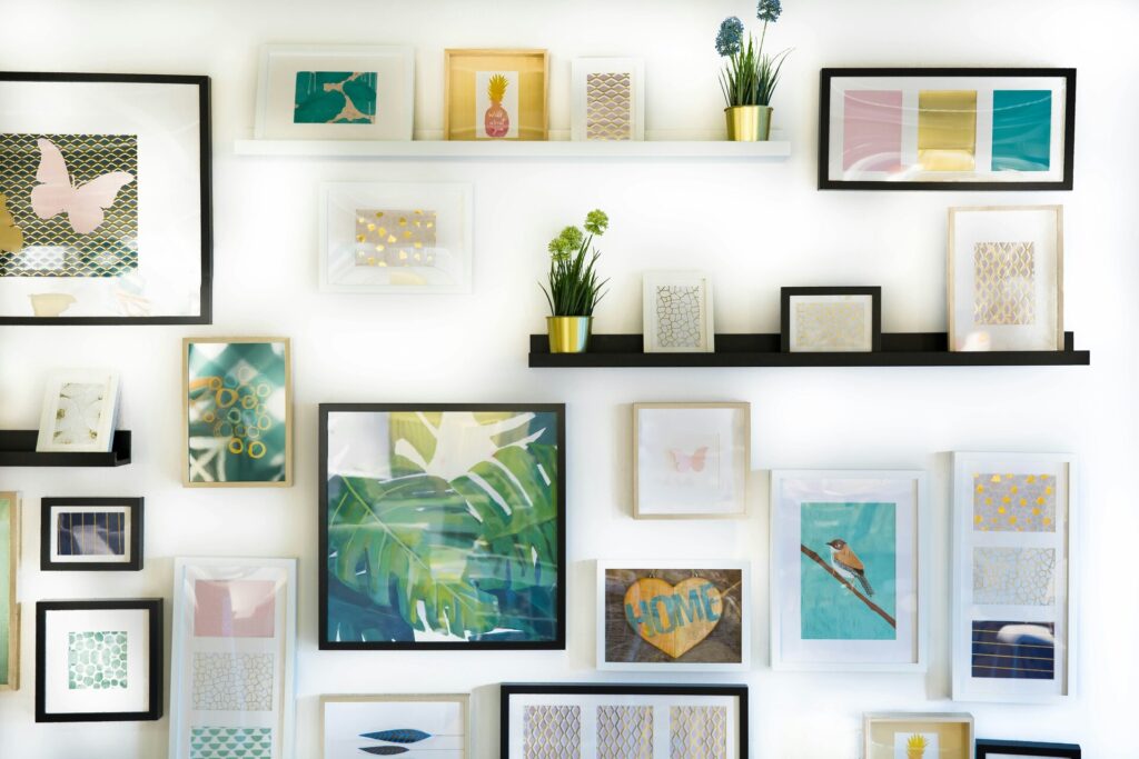 Framed pictures on a wall and shelves 