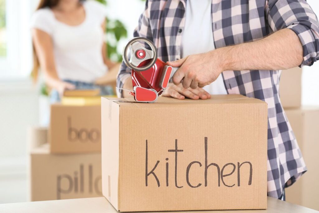 A person sealing a box from the kitchen