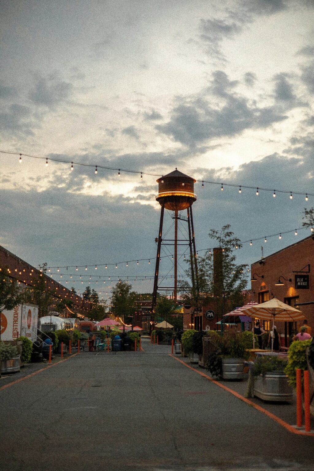 Historic street lined with colorful buildings and a prominent water tower in the background.